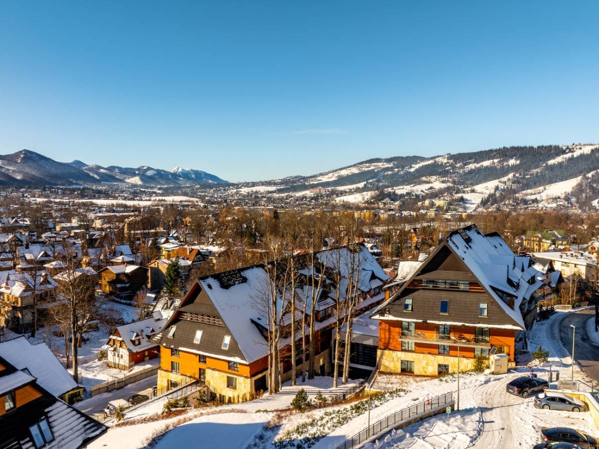 Radisson Residences Zakopane — widok z lotu ptaka na budynek w zimie z panoramą Tatr i miasta Zakopane