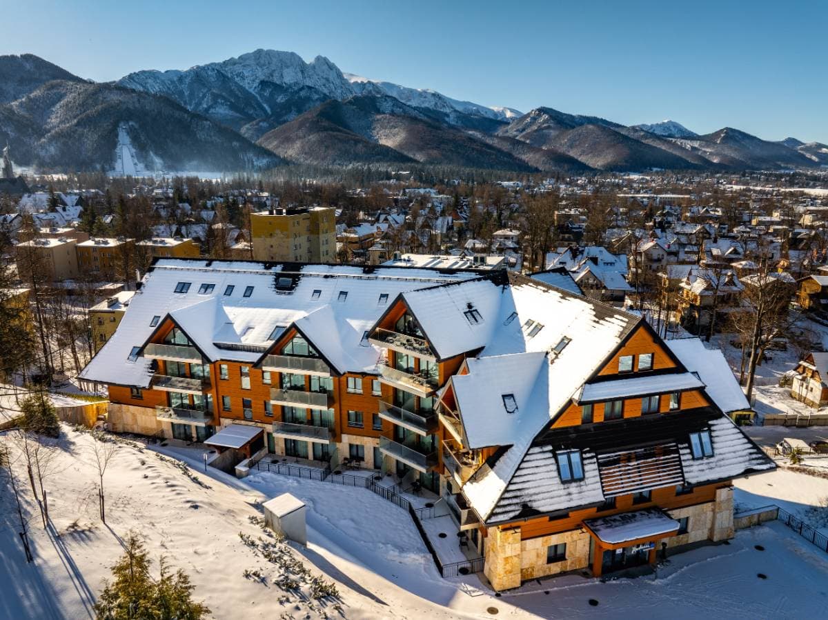 Radisson Residences Zakopane — widok z lotu ptaka na elewację w zimie z balkonami i widokiem na Giewont